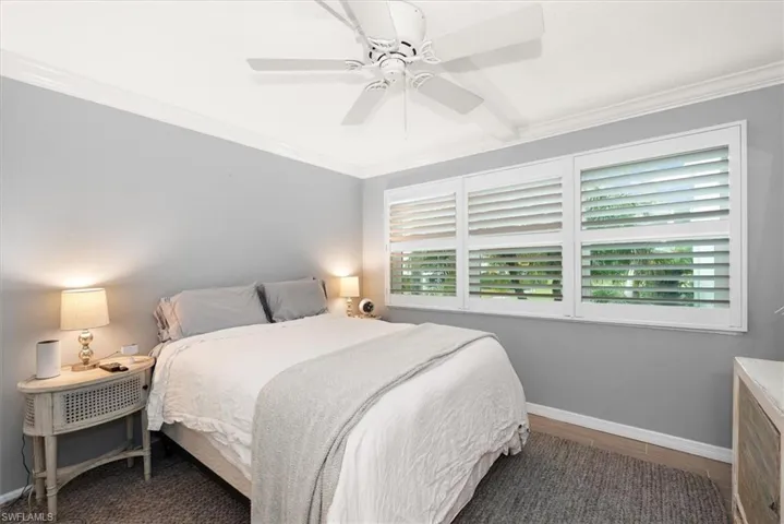 Bedroom with crown molding, ceiling fan and plantation shutters