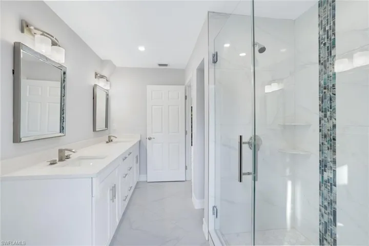 2nd floor bathroom with a double sink, frameless shower and cabana bath