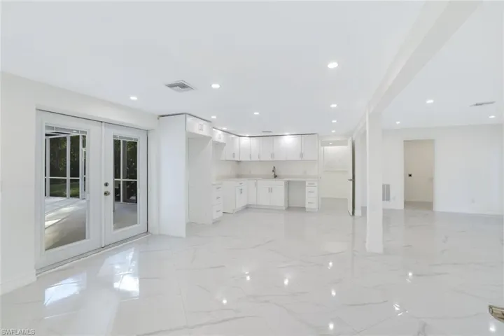 1st floor kitchen and  living room featuring french doors leading to the pool area