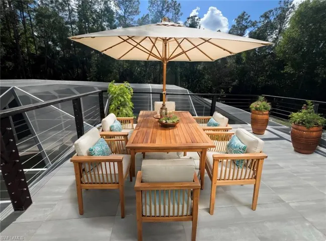 Staged view of 2nd floor balcony with a view of pool and wooded area