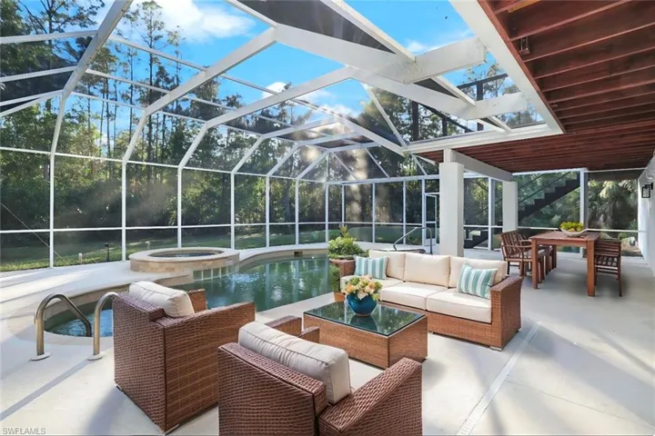 Staged view of patio terrace with a screen enclosure, an in ground hot tub, and an outdoor hangout area