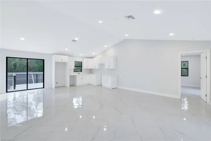 2nd floor living room featuring lofted ceiling and a full kitchen
