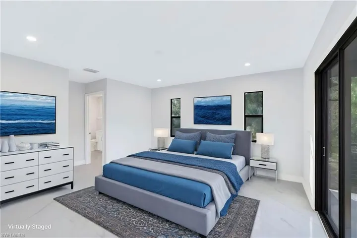 Staged 2nd floor Bedroom featuring connected bathroom amd access to balcony and a view of the pool