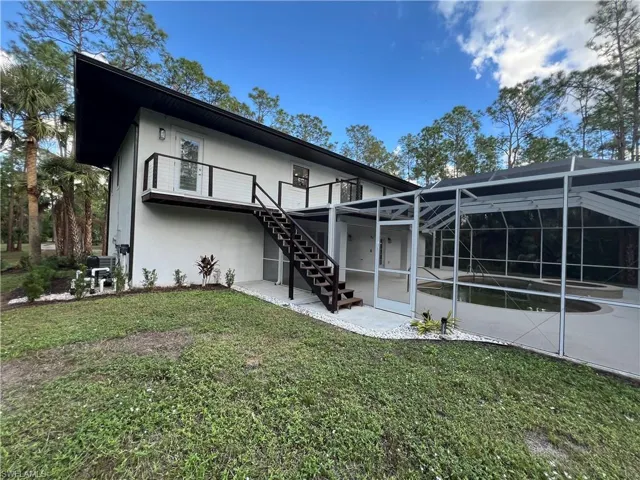Back of property with stairs that lead to the pool area