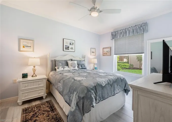 Bedroom with light wood-type flooring, ceiling fan, and ornamental molding