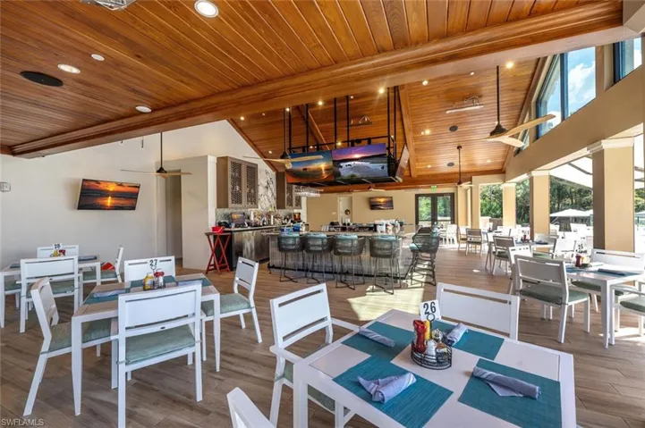 Dining area featuring ceiling fan, high vaulted ceiling, wood ceiling, and wood-type flooring