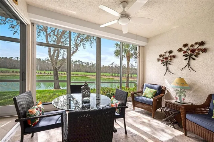 Sunroom featuring ceiling fan and a water view
