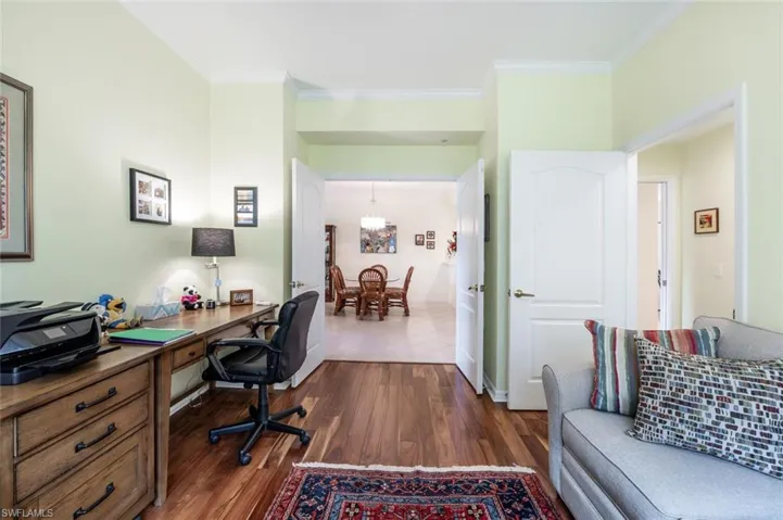 Home office featuring dark hardwood / wood-style flooring and ornamental molding