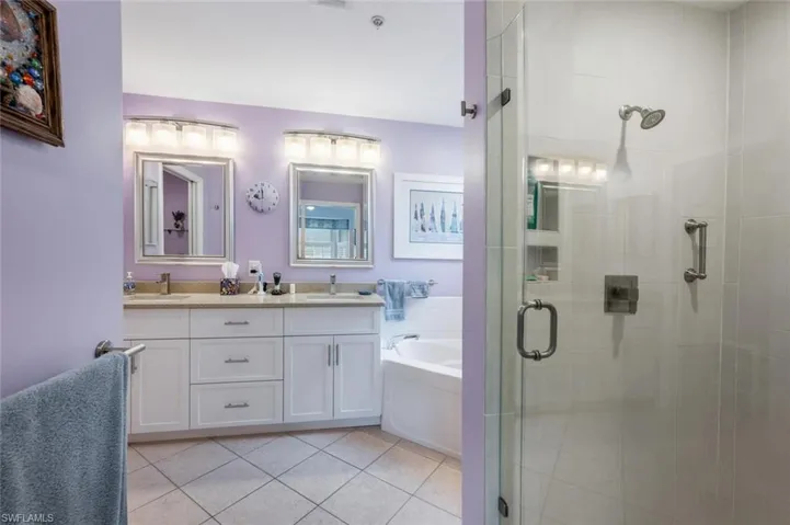 Bathroom with tile patterned floors, vanity, and plus walk in shower