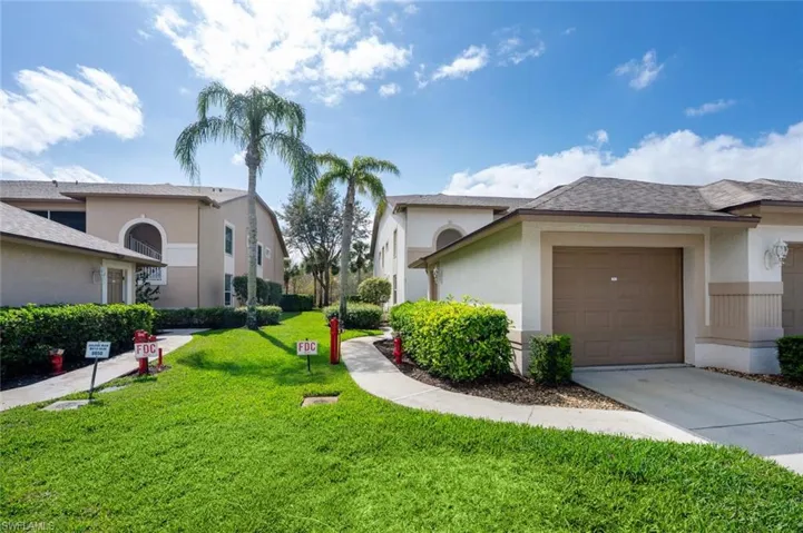 View of property exterior with a garage and a lawn