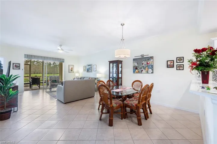 Tiled dining room with crown molding and ceiling fan