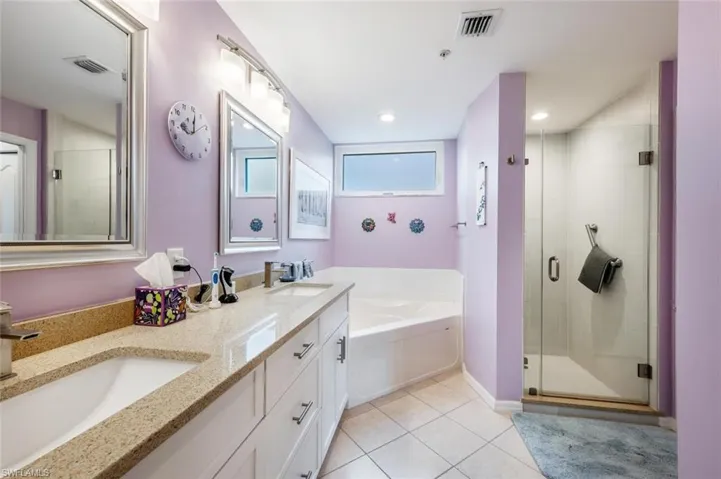 Bathroom featuring plus walk in shower, tile patterned flooring, and vanity