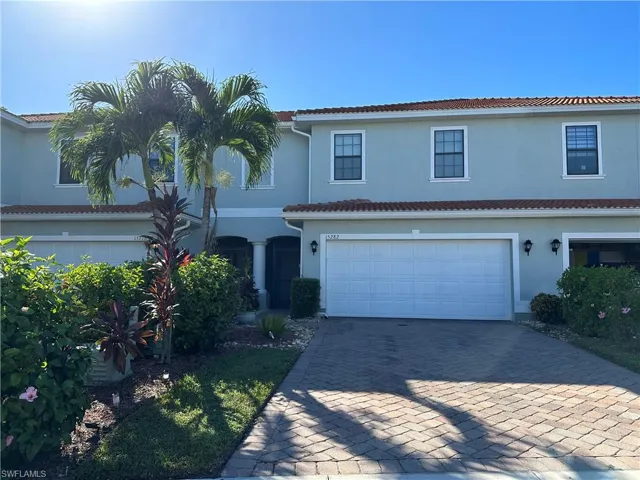 View of front of house with decorative driveway, stucco siding, an attached garage, and a tiled roof