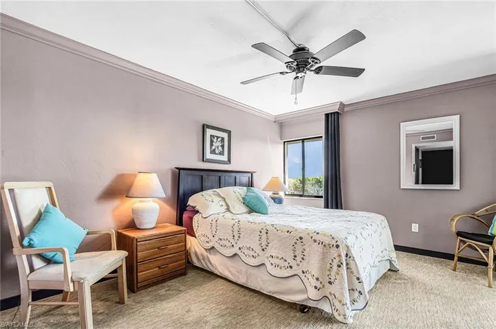 Bedroom featuring light carpet, ceiling fan, and crown molding