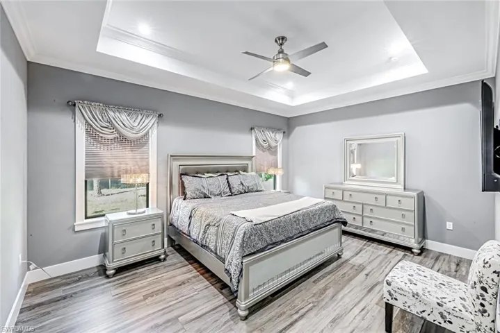 Bedroom with ornamental molding, ceiling fan, and light wood finished floors
