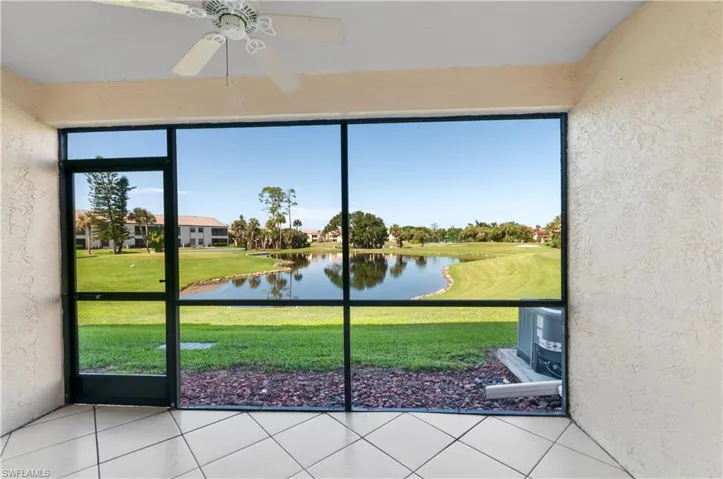 Unfurnished sunroom featuring ceiling fan and a water view