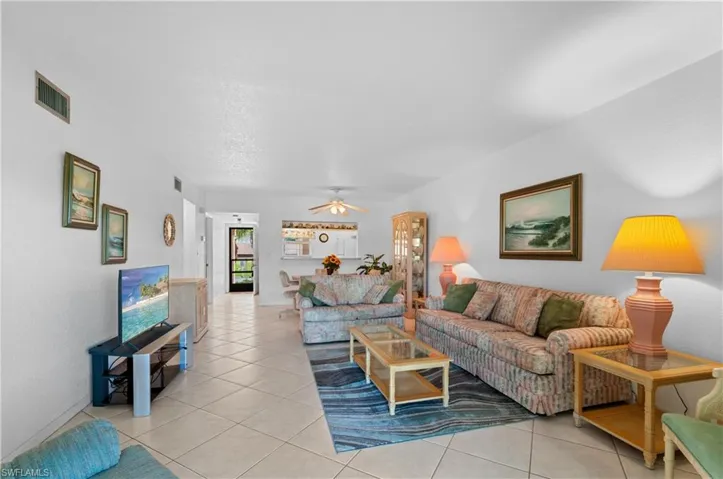 Living room with ceiling fan and light tile patterned floors