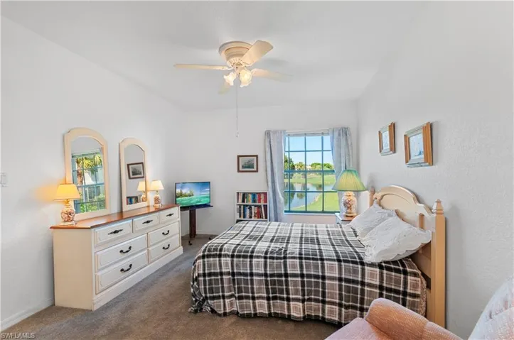 Carpeted bedroom featuring ceiling fan