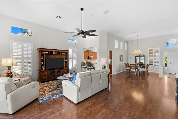 Living area featuring a high ceiling, dark wood finished floors, and a ceiling fan