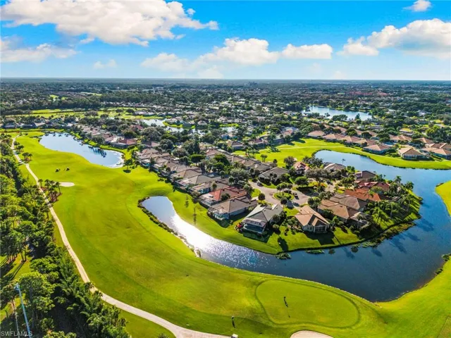 Aerial perspective of suburban area with a nearby body of water and a golf club