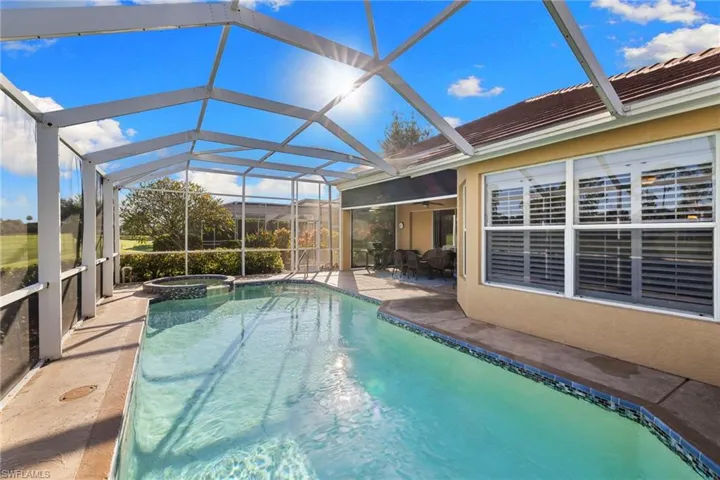 View of pool with a sunroom, glass enclosure, a pool with connected hot tub, a patio, and ceiling fan