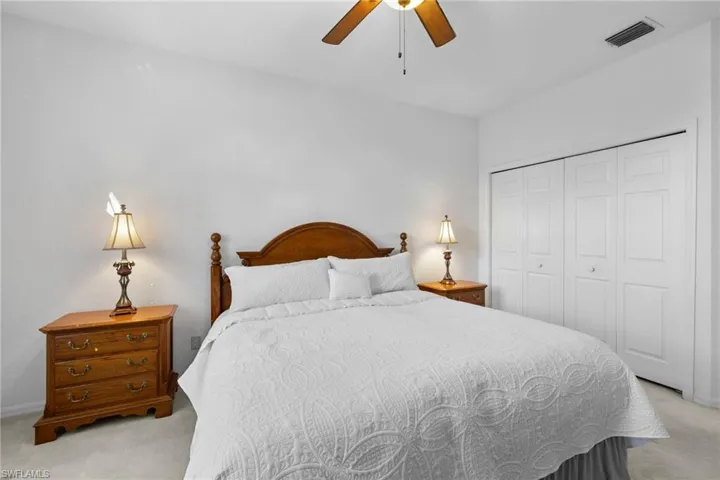 Bedroom featuring light colored carpet, a closet, and ceiling fan