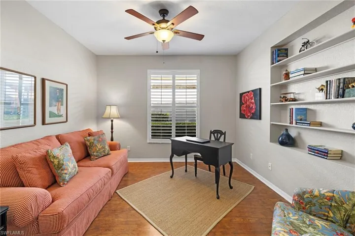 Office area with wood finished floors, ceiling fan, and a textured wall