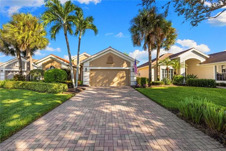 Ranch-style home featuring a front lawn, stucco siding, decorative driveway, and a garage