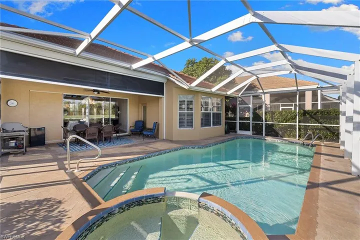 View of pool featuring a pool with connected hot tub, a sunroom, a patio area, and a lanai