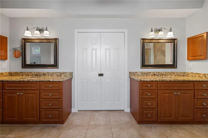 Bathroom featuring two vanities and a closet