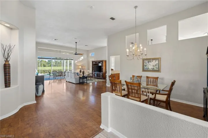 Dining space featuring dark wood-type flooring, a ceiling fan, and a chandelier