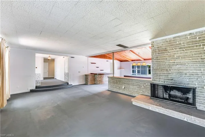 Unfurnished living room featuring a brick fireplace