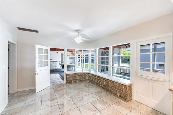 Unfurnished sunroom with ceiling fan