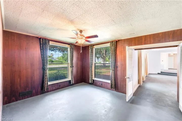 Empty room with wood walls and ceiling fan