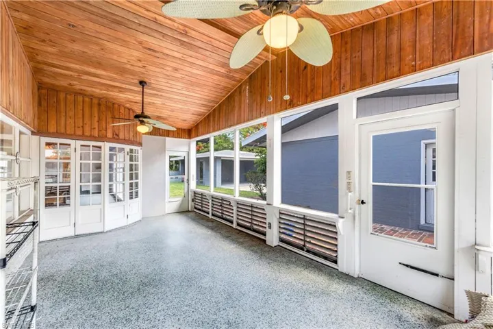 Unfurnished sunroom featuring wooden ceiling, ceiling fan, and vaulted ceiling