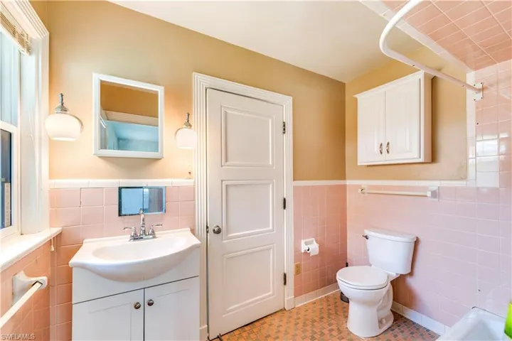 Full bathroom featuring vanity, tile walls, tile floors, toilet, and bathing tub / shower combination