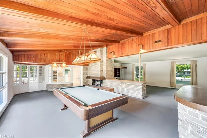Rec room with wooden ceiling, brick wall, vaulted ceiling with beams, and pool table