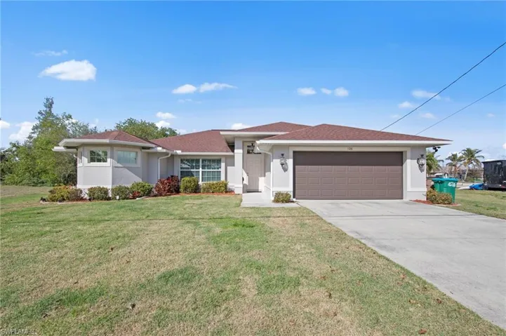 Single story home with stucco siding, a front lawn, driveway, an attached garage, and a shingled roof
