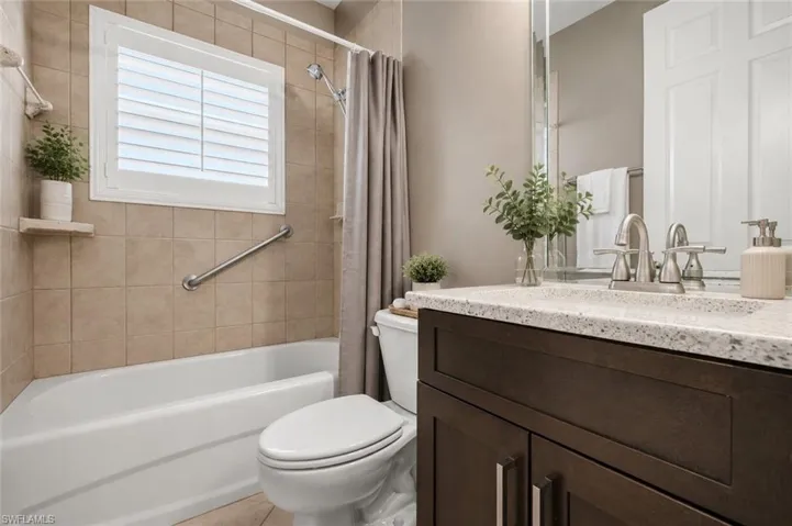 Bathroom featuring a dark wood-finish vanity with a light speckled countertop and a rectangular undermount sink