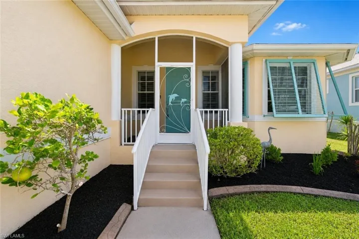 Inviting screened front entry featuring a decorative door with dolphin accents