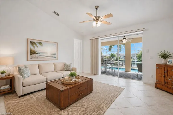 Spacious living area featuring vaulted ceilings, tile flooring, and a ceiling fan