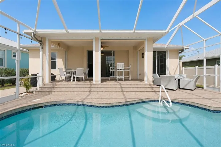 Screened swimming pool with integrated steps, surrounded by a paver deck
