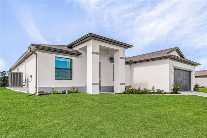 View of front of home with a garage, a front yard, and central air condition unit