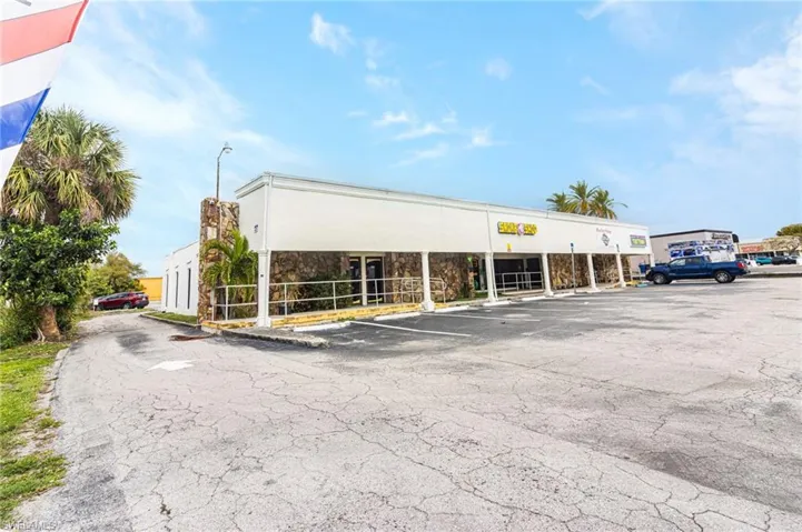 View of commercial property with uncovered parking
