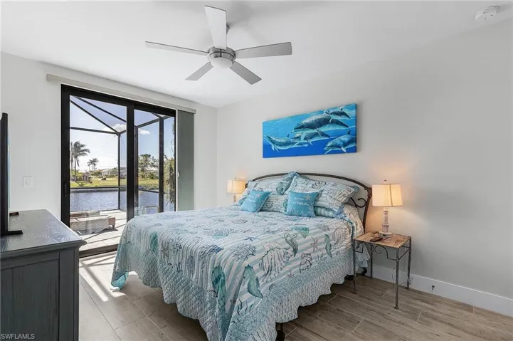 Bedroom with tile flooring, a water view, and ceiling fan