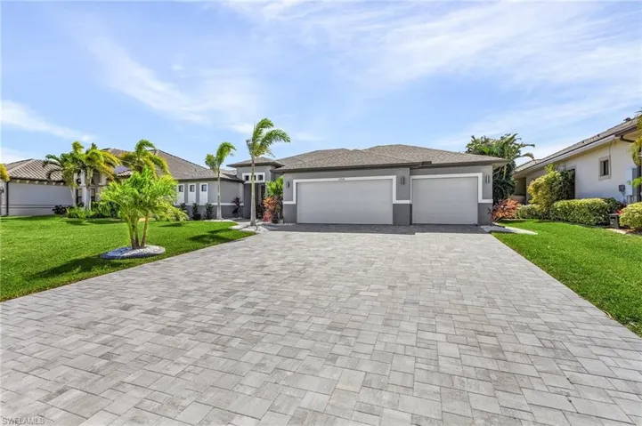 View of front facade featuring a front yard and a garage