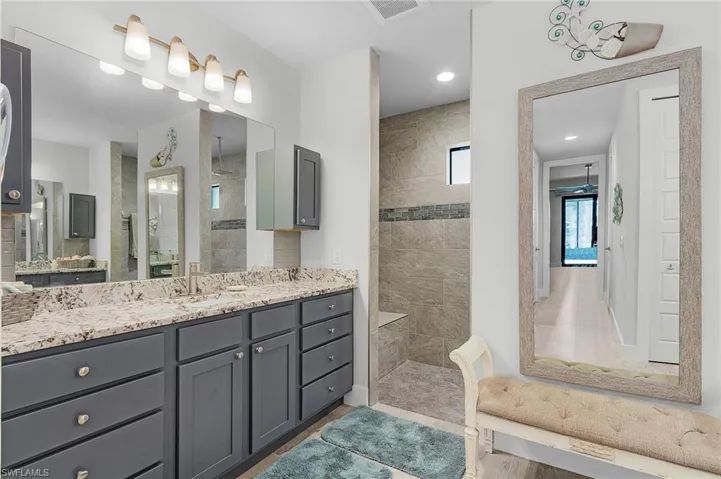 Bathroom featuring vanity, wood-style tile floors, and a tile shower