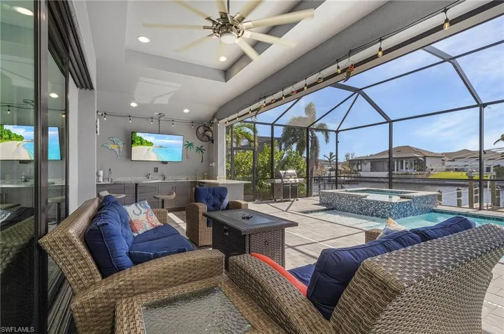 View of patio / terrace featuring ceiling fan, a pool with hot tub, and a lanai