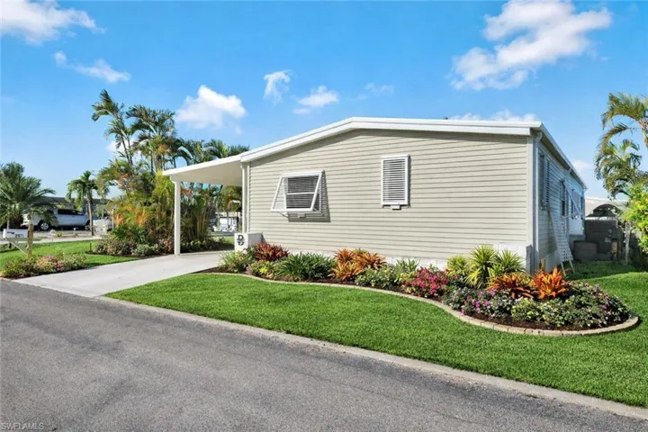 Front exterior showcasing the POTENTIAL low-maintenance landscaping and inviting entrance to this move-in ready St. James City home. *AI ENHANCED