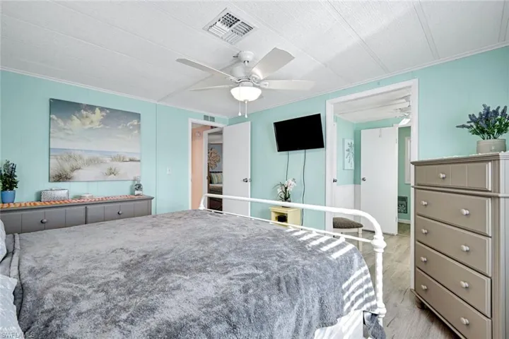 Primary suite with en-suite access and bright coastal décor creating a relaxing atmosphere.
